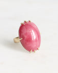 Ring with a pink stone and gold accents on a white background