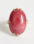 Ring with a large pink stone and gold accents on a white background