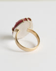 Gold ring with a red gemstone on a white background