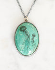 Necklace featuring a bezel set turquoise in oxidized silver. The turquoise features two jellyfish engravings.