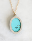 Back of necklace with a small scrimshaw fish.