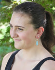 Woman with a ponytail wearing earrings outdoors