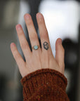Hand wearing blue gemstone ring.