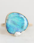 Large opal set in a bezel with silver barnacles clinging to the bezel.
