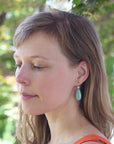 Woman wearing earrings with a blurred natural background