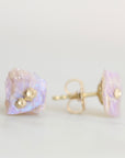 Raw opal studs with gold barnacle details against a white background.