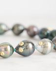 Pearl necklace with gold accents on a light background
