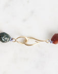 Close-up of a necklace with beads and a gold clasp on a white background