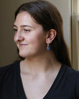 Woman wearing a black top with a neutral background