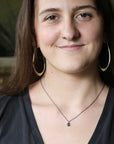 Woman wearing small blue stone necklace