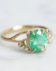 Bright green stone ring with diamonds and branchy prongs