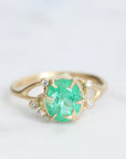 Bright green stone ring with diamonds and branchy prongs