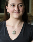 woman wearing large moss agate stone pendant