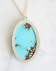 Back of necklace featuring a bezel set turquoise with natural veining and a small engraved fish