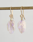 Pale colored fossilized opals suspended from gold ear wires with rose detailing.