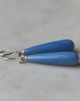 long teardrops of blue common opal hang beneath silver ear wires and roses