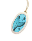 A turquoise pendant with a scrimshaw mermaid illustration on a long silver chain, picture of the reverse side showing the mermaid's tail.