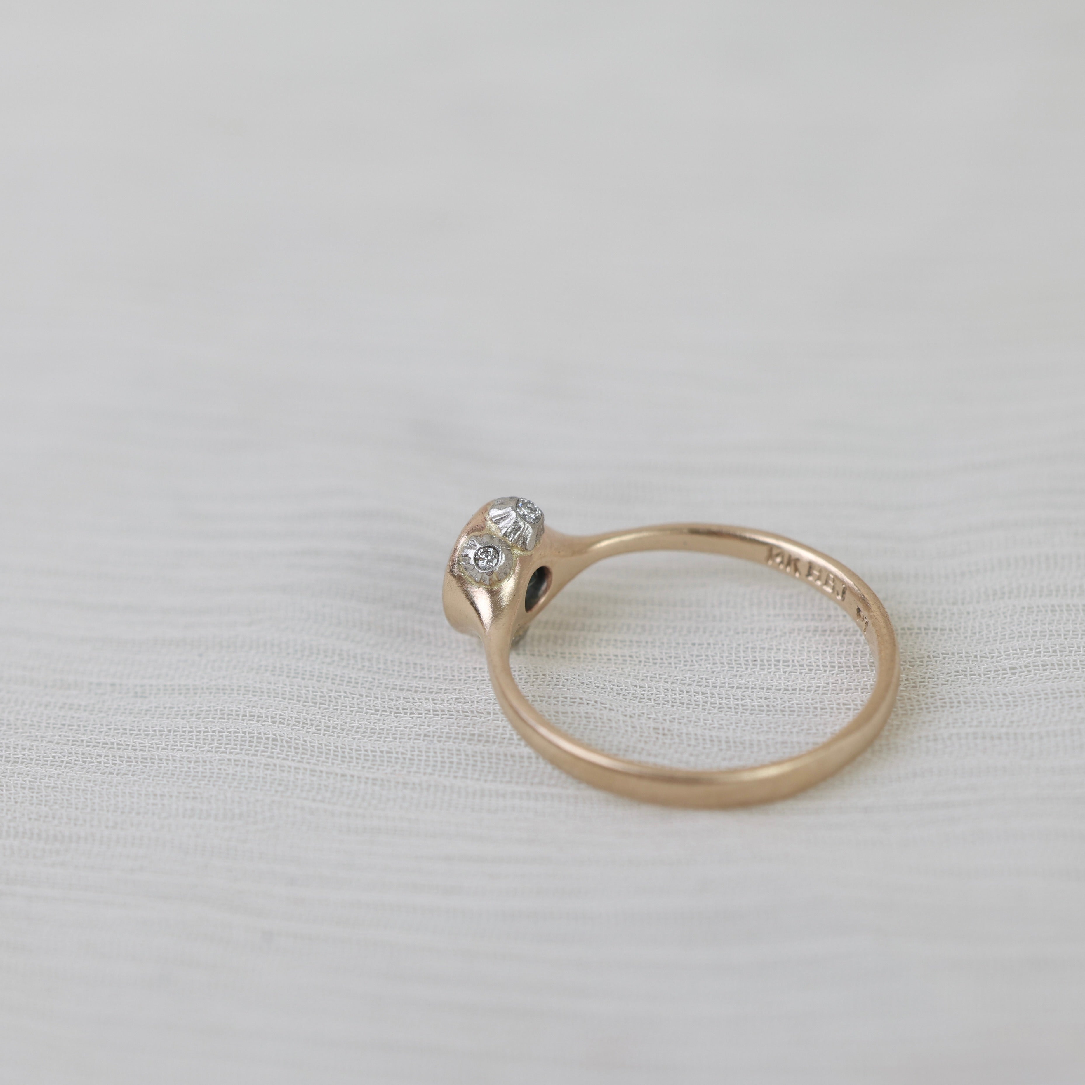 Gold ring with a diamond on a light gray background