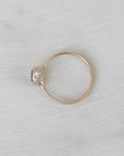 Gold ring with a diamond on a light gray fabric background