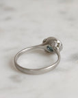 Silver ring with gemstones on a marble surface