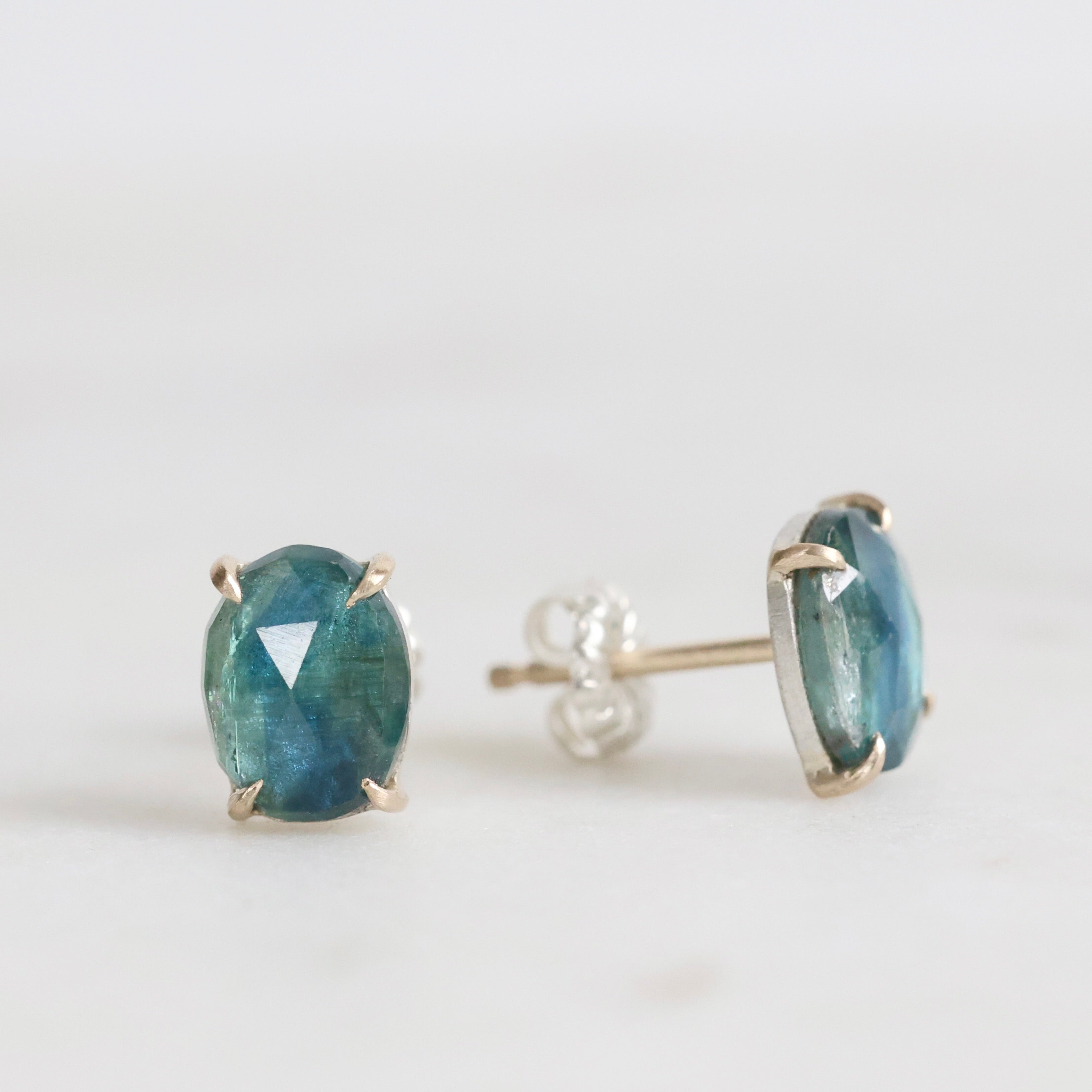Pair of blue gemstone stud earrings on a white background