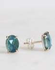 Pair of blue gemstone stud earrings on a white background
