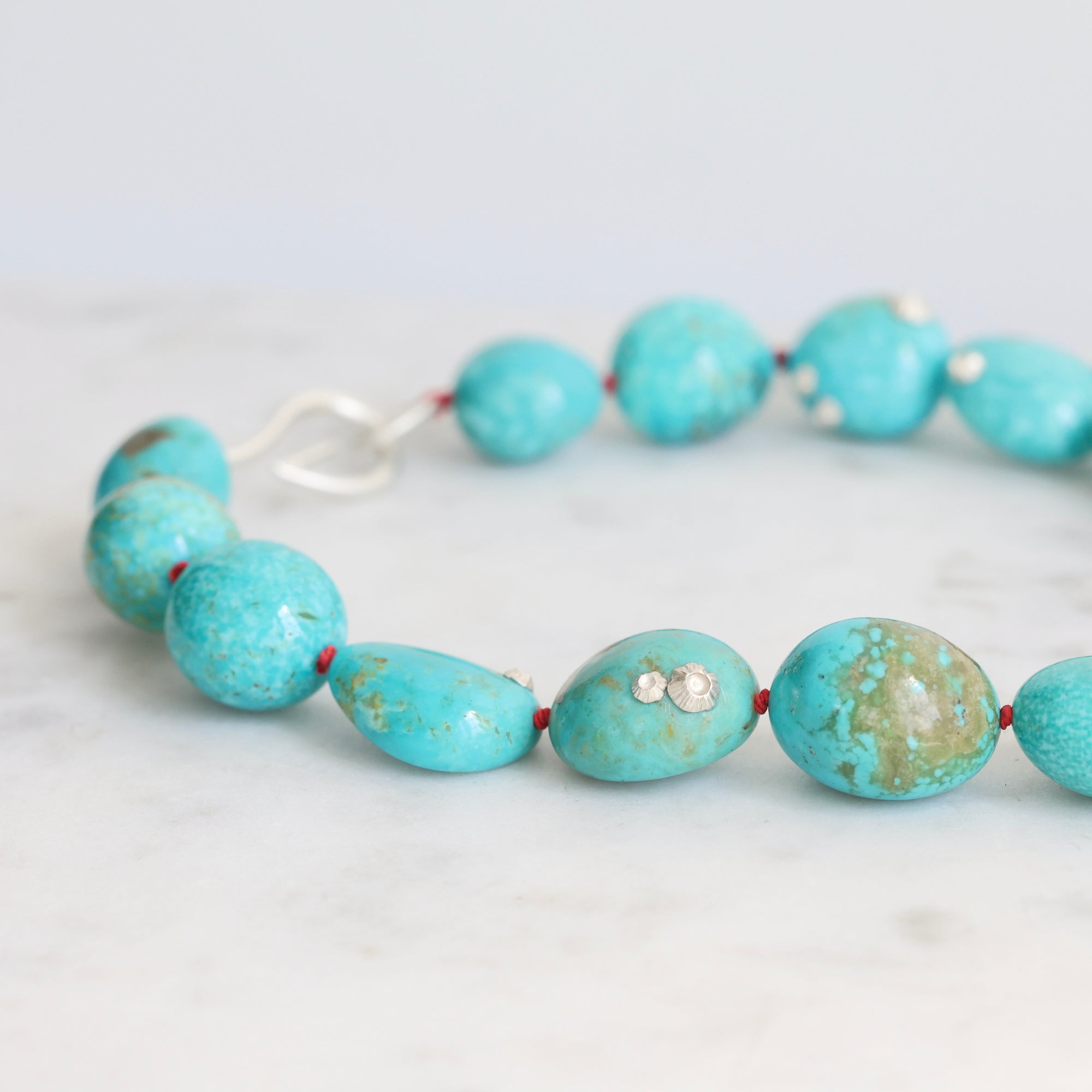Turquoise Strand with silver barnacles and red thread