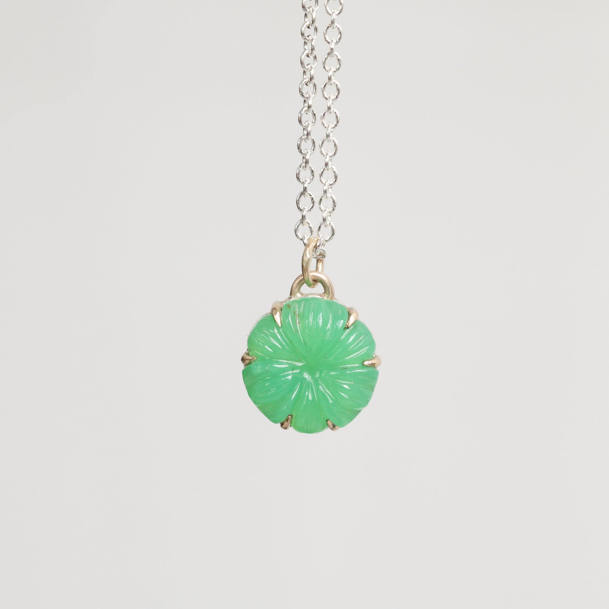Necklace with a green pendant on a light gray background
