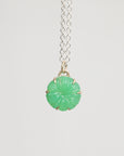 Necklace with a green pendant on a light gray background