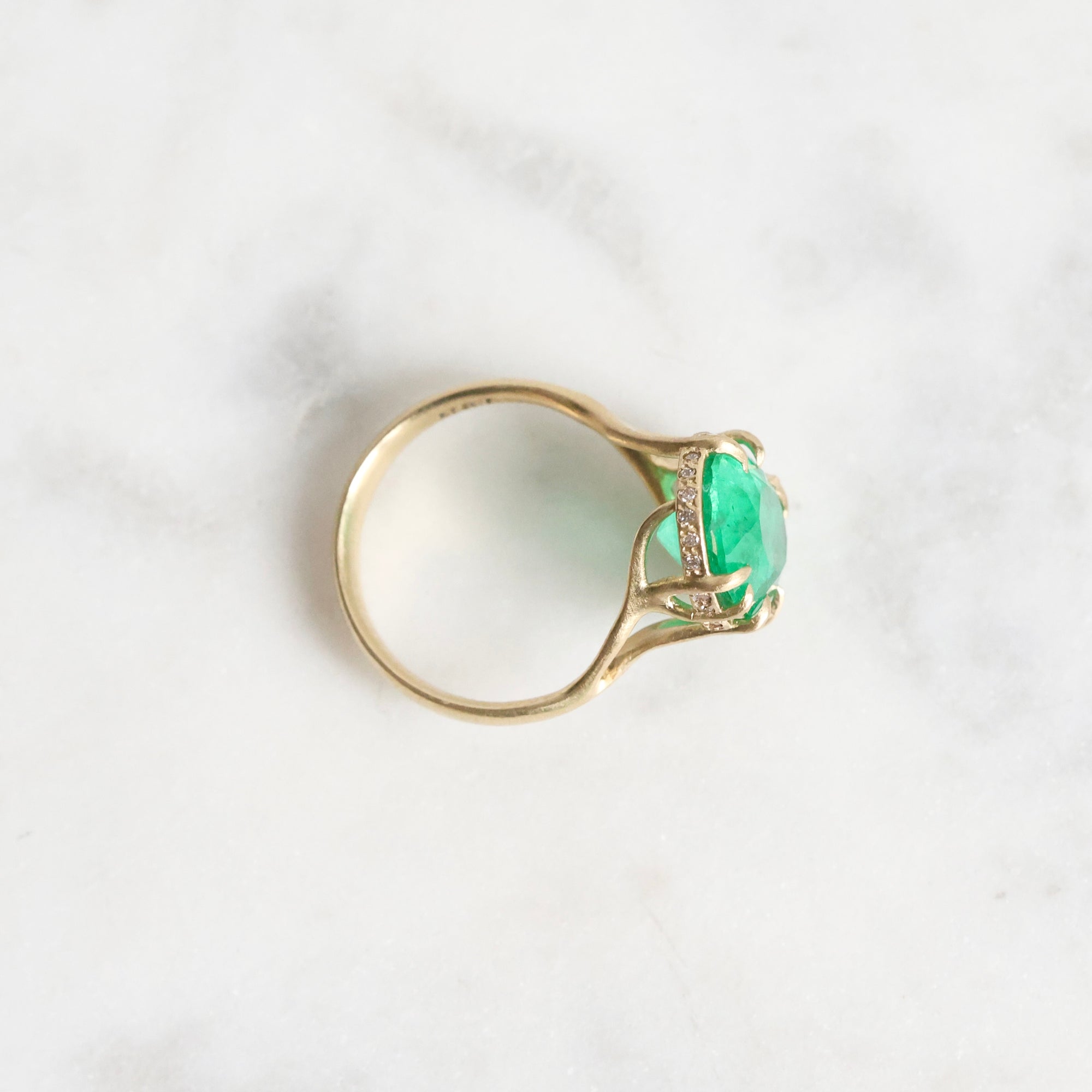 Large green gemstone ring with a diamond halo and branchy setting