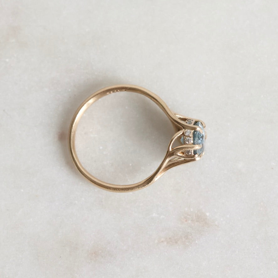 Gold ring with a diamond on a light marble background
