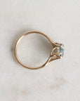 Gold ring with a diamond on a light marble background