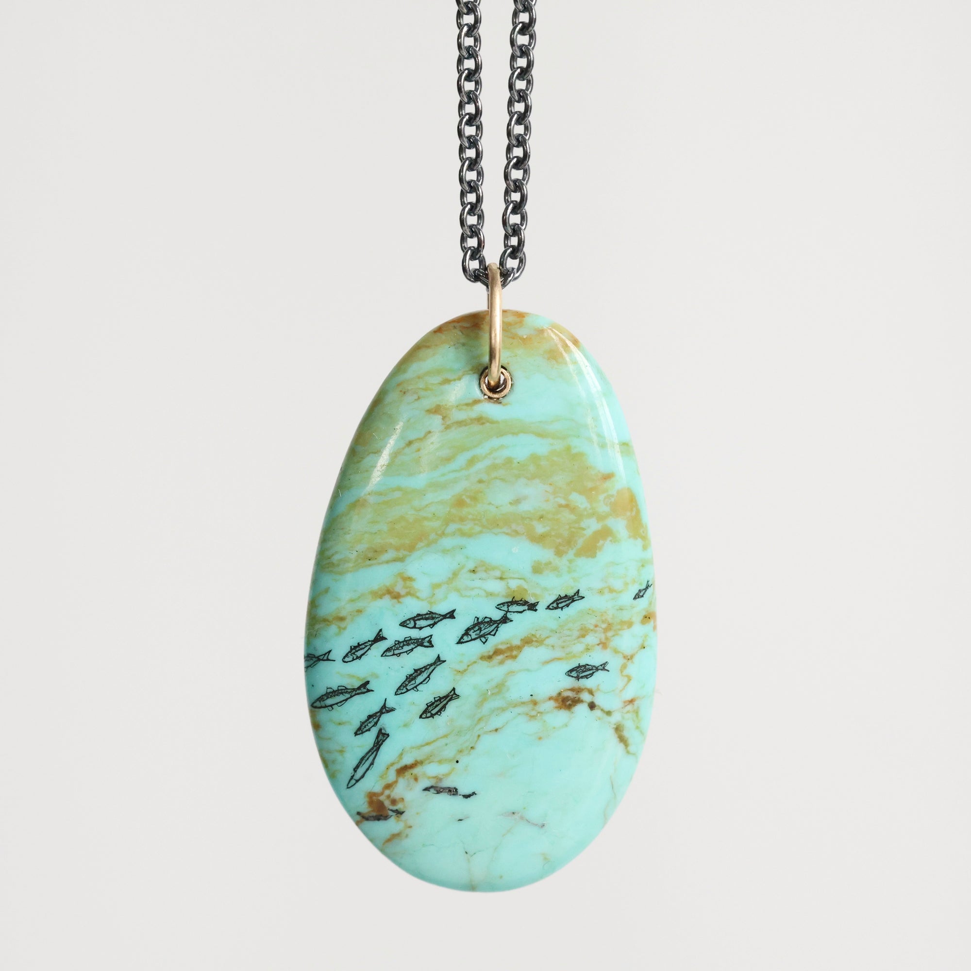 Turquoise marbled pendant necklace on a light gray background