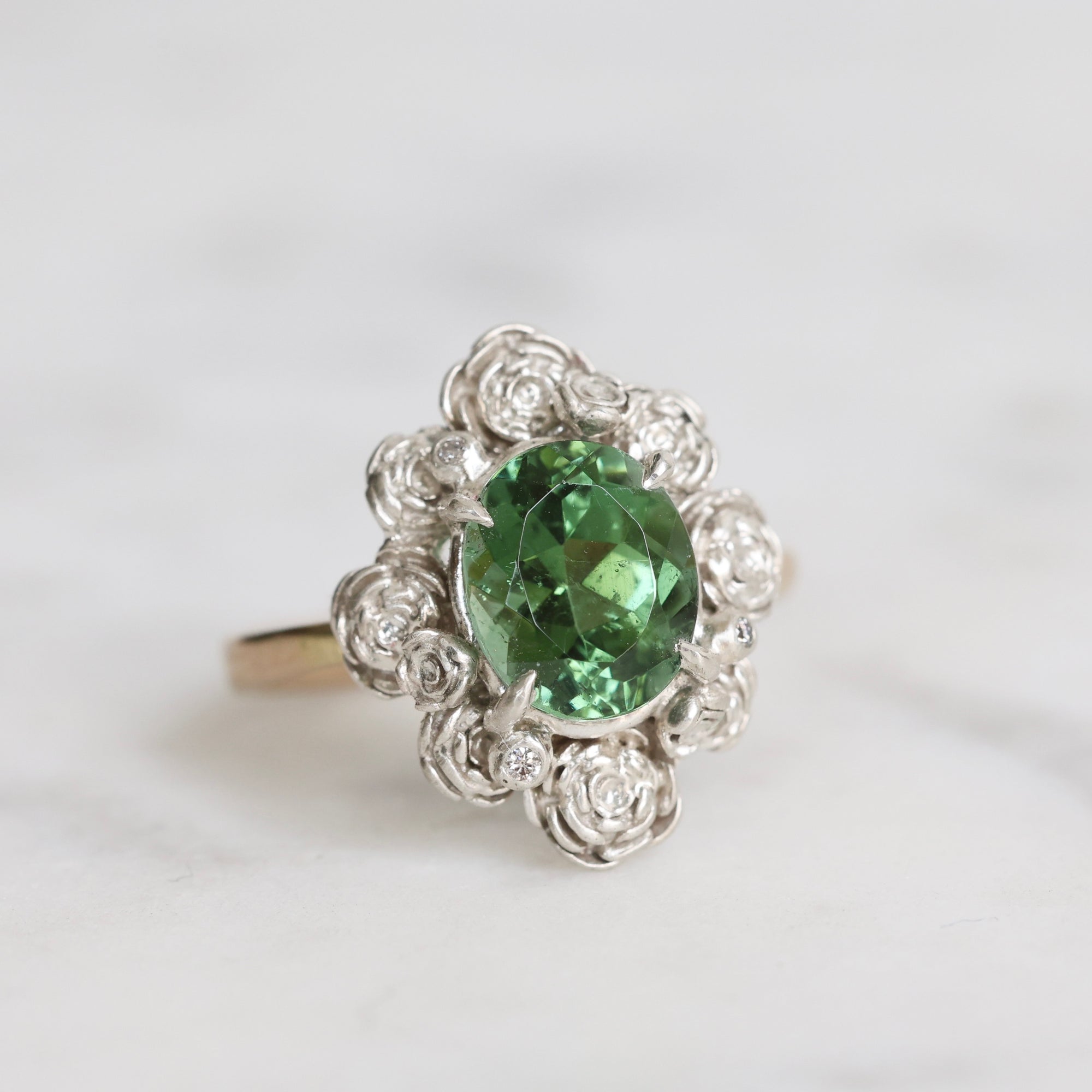 Silver ring with a green gemstone on a white background