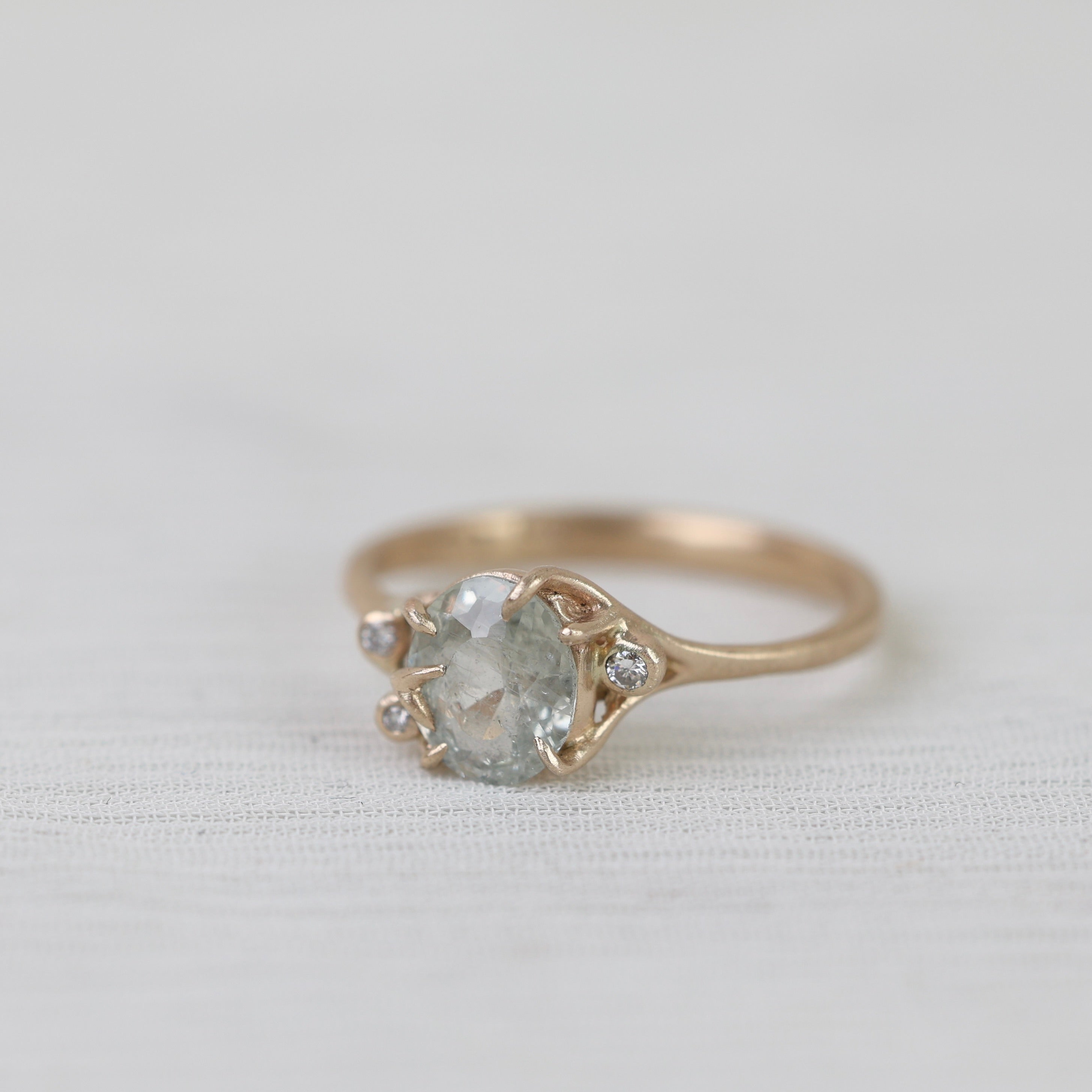 Gold ring with a gemstone on a light gray background