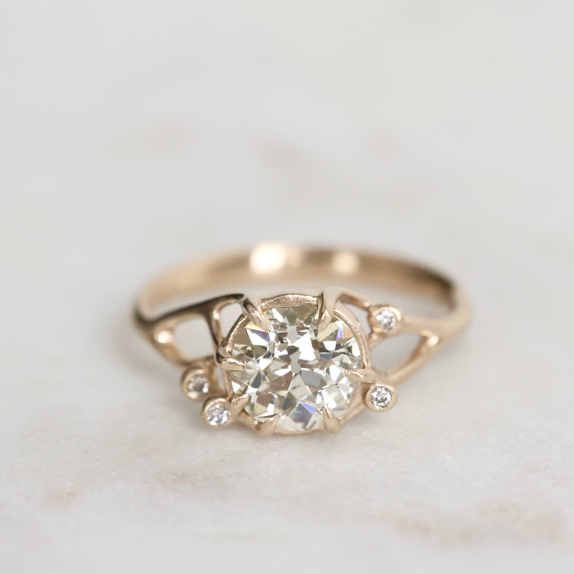 Gold ring with a diamond on a light gray background