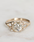 Gold ring with a diamond on a light gray background