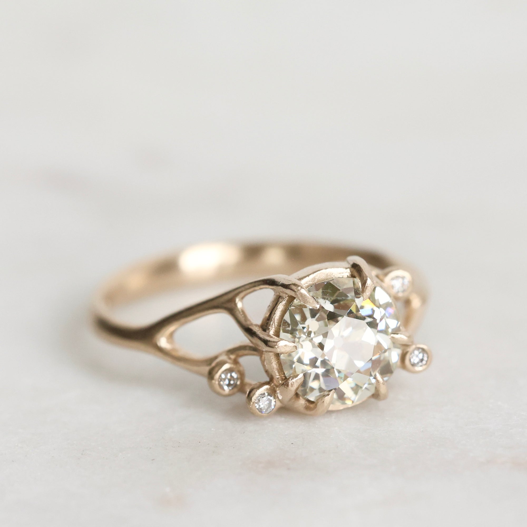 Gold ring with a diamond on a light gray background