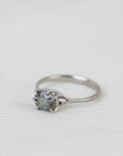 Silver ring with a gemstone on a white fabric background