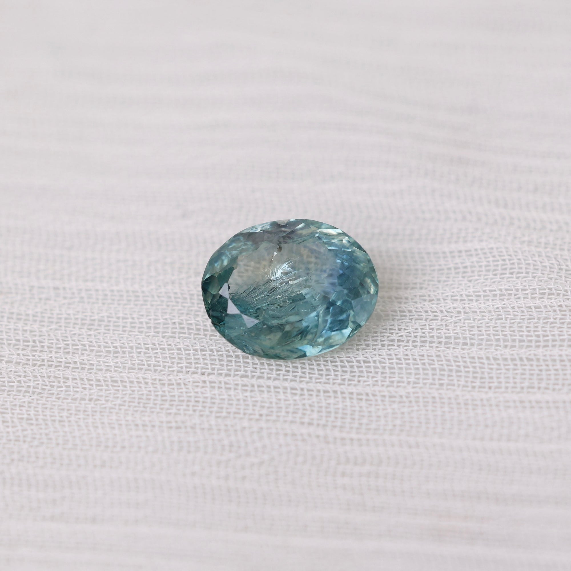 Blue gemstone on a white fabric background