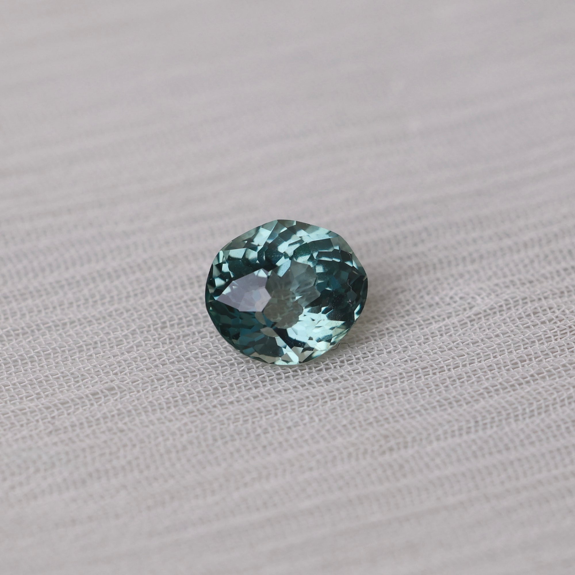 Green gemstone on a textured gray background