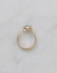 Gold ring with a gemstone on a light gray fabric background