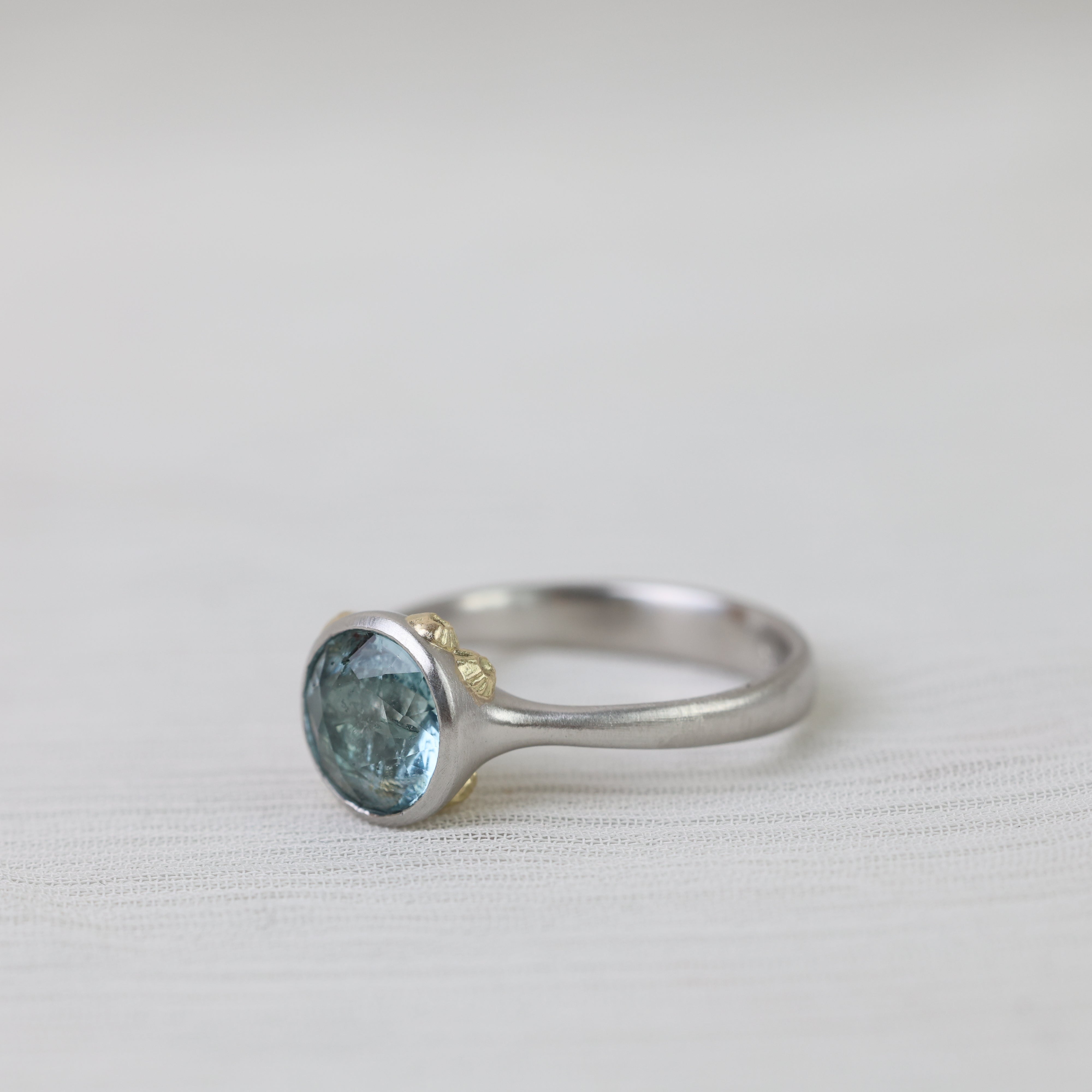 Silver ring with a blue stone on a white background