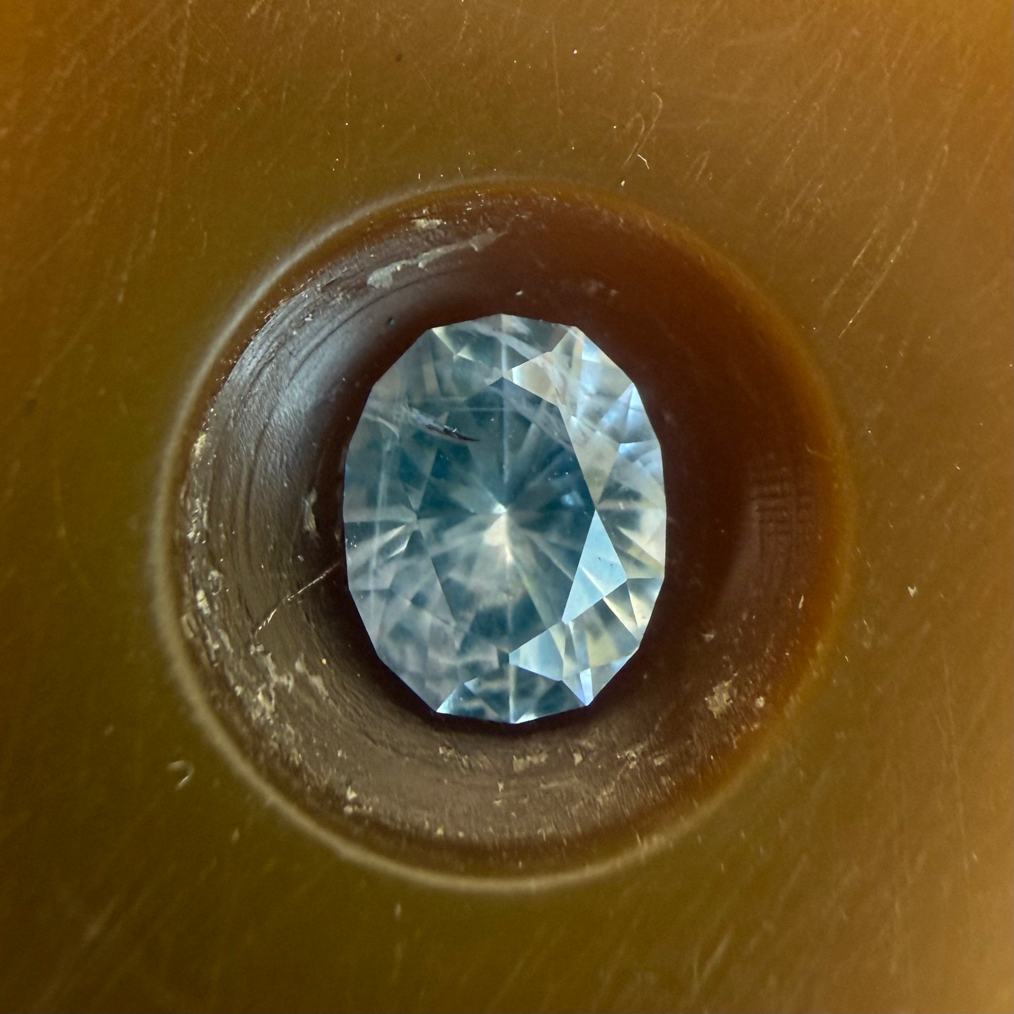 Blue gemstone in a brown circular setting