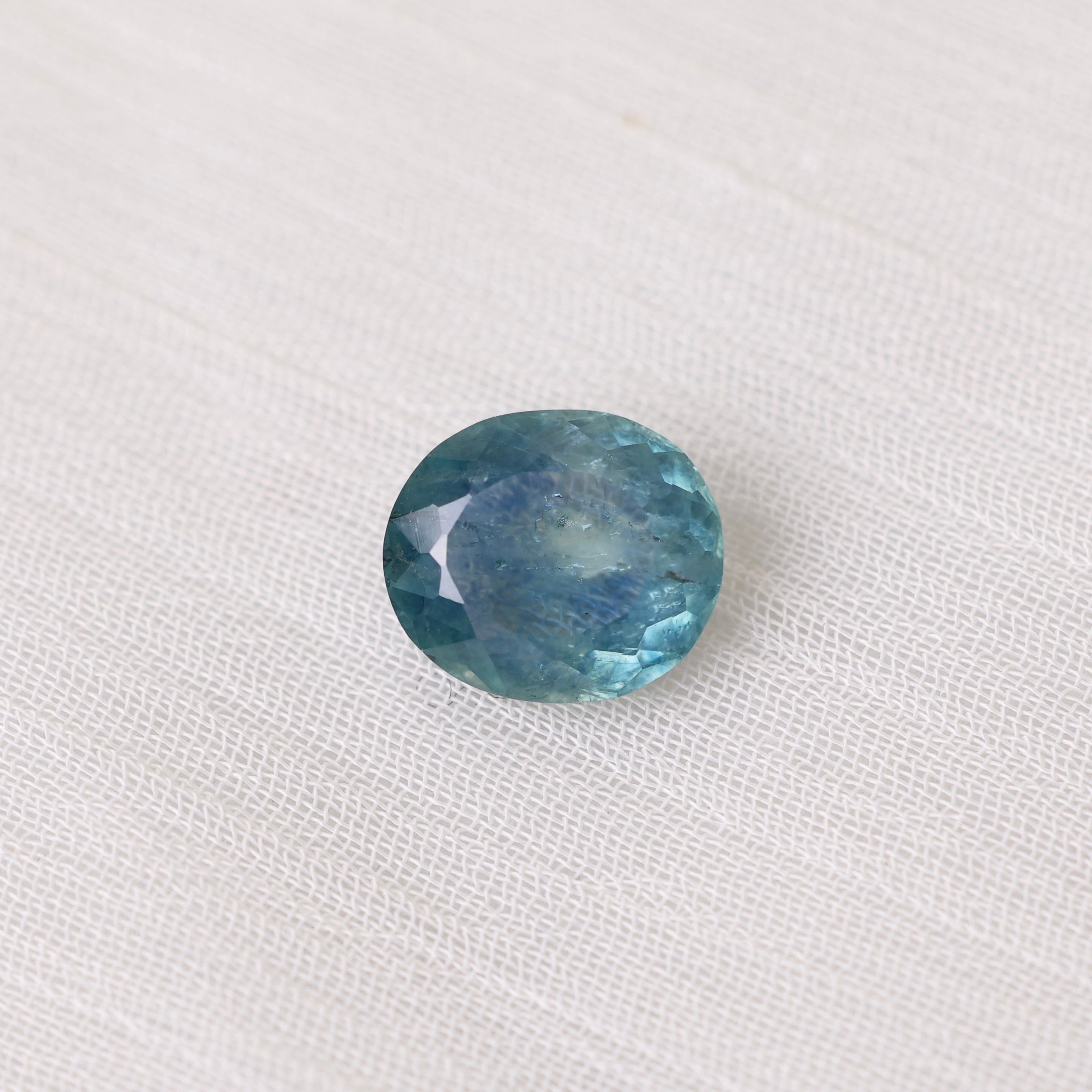 Blue gemstone on a white fabric background
