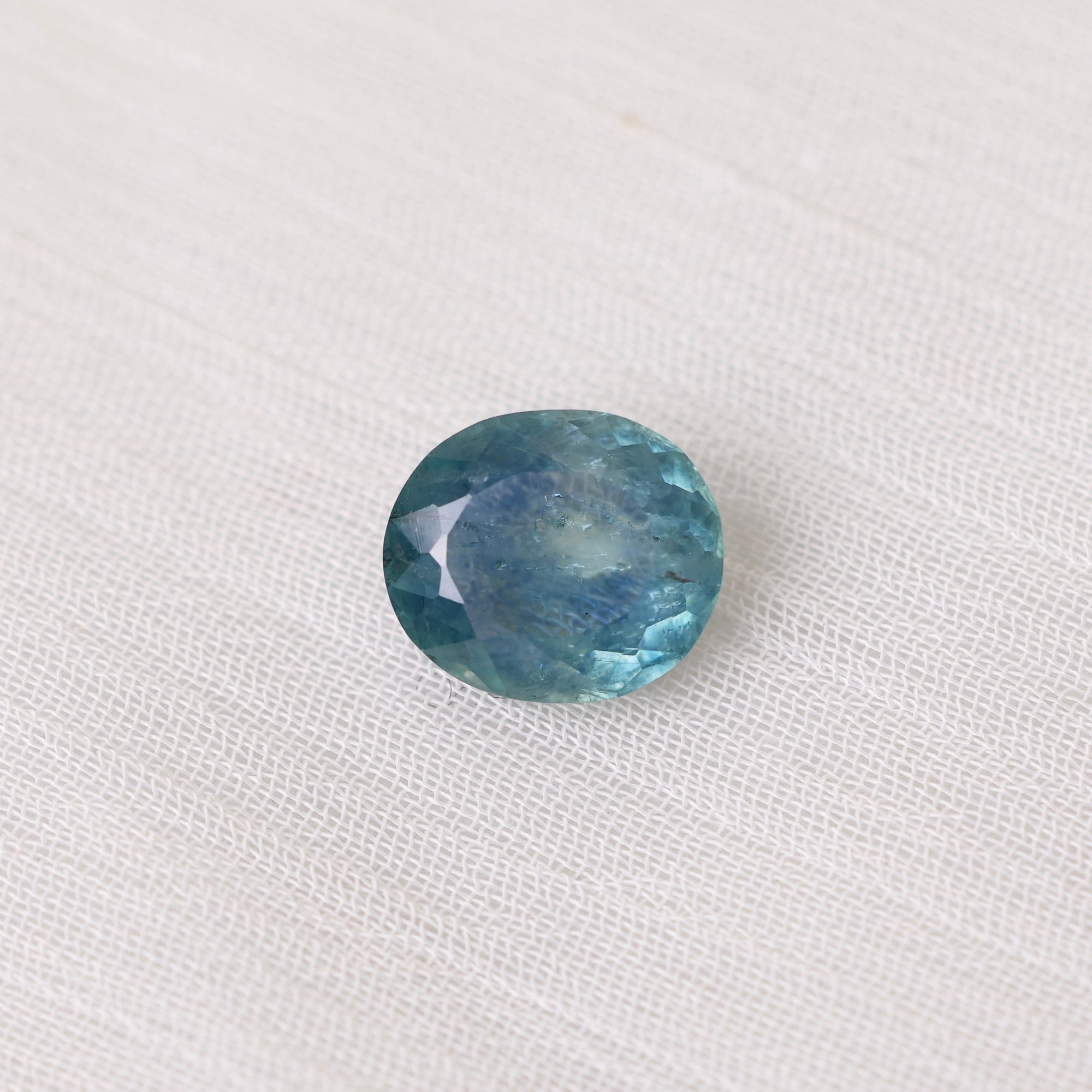 Blue gemstone on a white fabric background