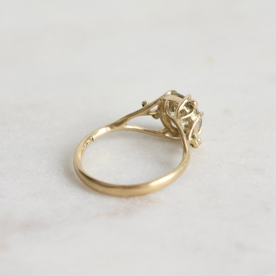 Gold ring with a diamond on a light gray background