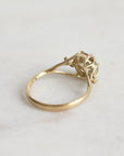 Gold ring with a diamond on a light gray background
