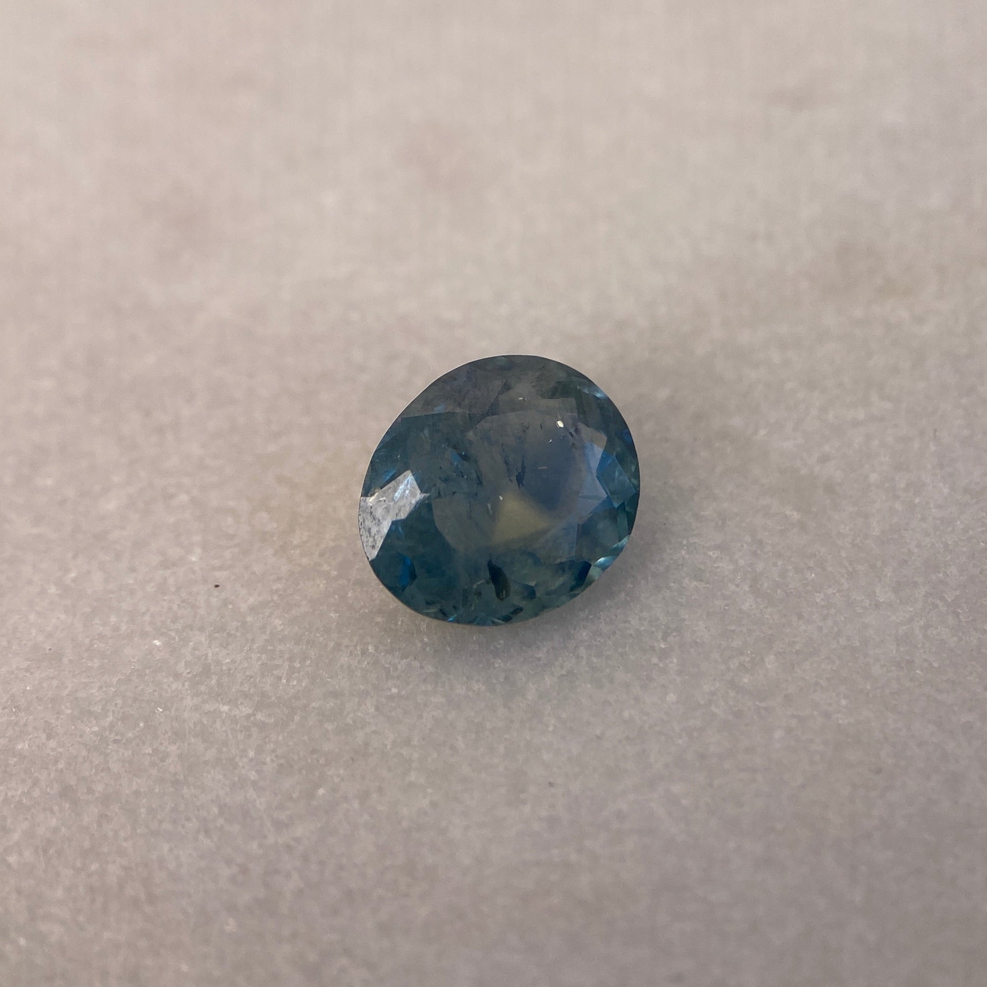 Blue gemstone on a textured beige background