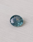 Faceted blue gemstone on a light fabric background
